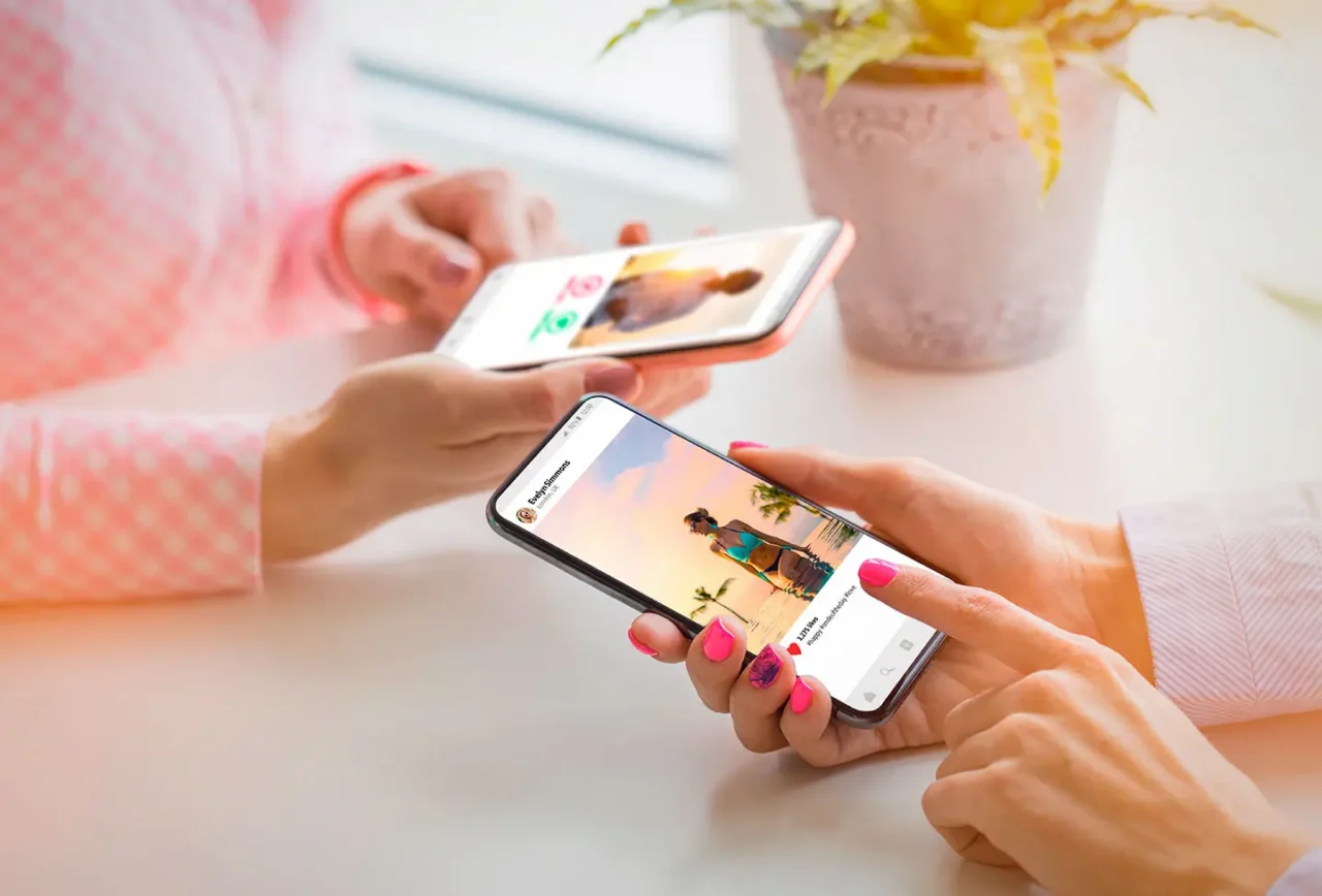 Dos personas viendo fotos en Instagram desde sus móviles, revisando perfiles y publicaciones coloridas en la red social.
