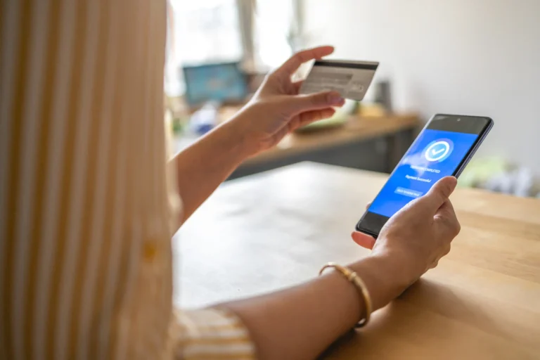 Mujer comprando cuenta de Reddit para OnlyFans con smartphone y tarjeta bancaria